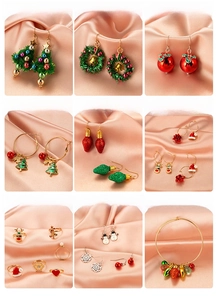 Detailed grid of festive gold metal Christmas earrings and rings with enamel holiday charms