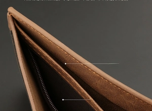 Detail of brown leather wallet featuring a large bill pocket and a secure zipper compartment