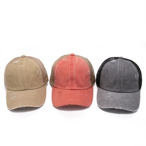 Macro detail of distressed washed denim baseball caps with frayed edges and mesh back