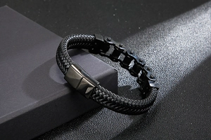 Detail of black braided leather strap with metal bike chain link and magnetic clasp