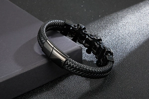 Macro shot of men's black braided leather bracelet featuring industrial bike chain details