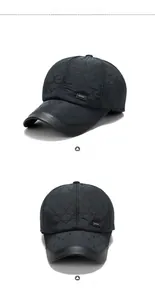 Detail of black quilted baseball cap with SPORT label and leather trimmed visor brim
