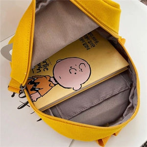 Internal view of a yellow canvas crossbody bag showing spacious capacity for kids