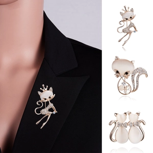 Détail d'une broche chat avec opale et strass sur le revers d'une veste