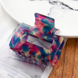 Detail of a rectangular marble acetate hair claw clip with pink and blue textures