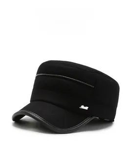 Detail view of winter flat cap showing premium black fabric and silver metal logo