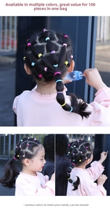 Detail showing colorful elastic hair bands used in a child's braided hairstyle