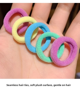 Close-up of five colorful seamless plush elastic hair bands held in hand for children