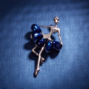 Detailed close-up of a dancing girl brooch with blue gemstones and sparkling rhinestones