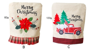 Detail of Christmas chair covers with embroidered poinsettia and festive truck designs