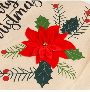 Close-up of linen Christmas chair cover featuring red poinsettia and leaf embroidery