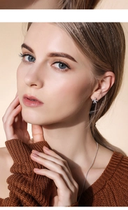 Detail of star-shaped 925 silver stud earrings with small stones on a female model