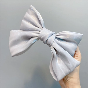 Detail of large silver-grey pearlescent organza bow hair clip with fine shimmering texture