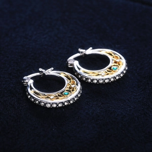 Pendientes de aro étnicos bicolor con piedra verde central sobre terciopelo azul