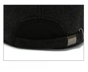 Detail of adjustable metal buckle and textured grey herringbone fabric on winter cap