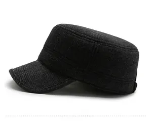 Dettaglio del cappello piatto in lana nera con logo M in metallo e tessuto spesso