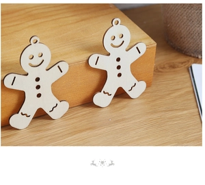 Detail of two wooden gingerbread man ornaments with cutout details and rustic wood grain