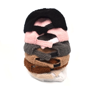 Vertical stack of six plush sherpa baseball caps in various neutral and pastel colors