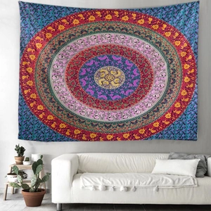 Detailed close-up of a colorful mandala tapestry hanging on a wall behind a white sofa