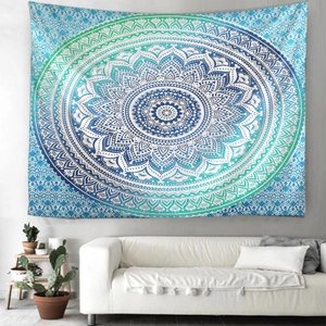 Detail of teal mandala tapestry hanging on white wall over a sofa in a modern living room