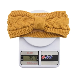 Detailed view of yellow cable-knit headband with warm fleece lining and bow design