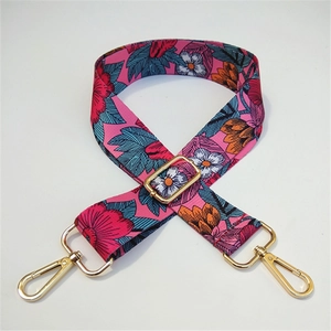 Close-up of pink floral fabric bag strap with adjustable golden metal hardware