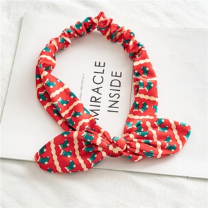 Détail du bandeau de Noël en velours rouge avec motif chaussettes et nœud festif