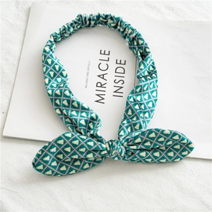 Détail du bandeau oreilles de lapin vert avec motifs blancs et texture en velours