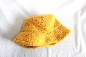 Flat lay macro view of the bright yellow faux shearling fabric and warm bucket hat texture