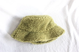 Detail shot of the thick light green lamb wool fabric texture on the warm winter bucket hat