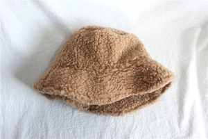 Close-up of brown faux shearling bucket hat with thick warm texture for winter
