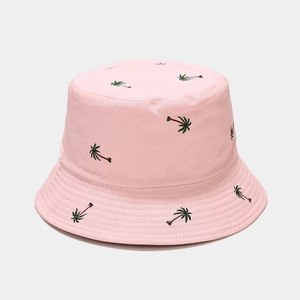 Close-up of pink bucket hat featuring detailed palm tree embroidery and fine cotton texture