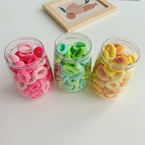 Detailed view of colorful gradient elastic hair ties in transparent storage jars