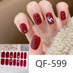 Detail of red Christmas nail stickers with white reindeer patterns on warm knit fabric