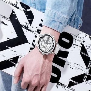 Detail of oversized quartz watch with white dial and resin strap on a skateboard