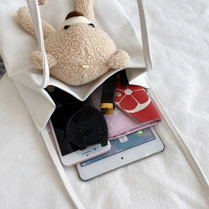 Sac fourre-tout en toile blanche avec ours en peluche montrant une grande capacité intérieure