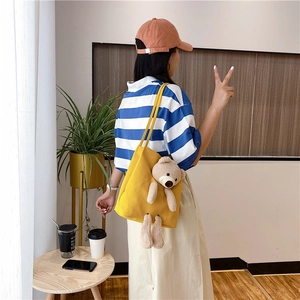 Détail du sac fourre-tout en toile jaune vif avec un mignon pendentif ours en peluche