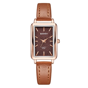 Detail of rectangular rose gold watch case with burgundy dial and brown leather strap