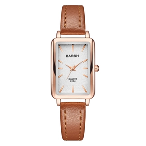 Close-up of vintage rectangular quartz watch with rose gold case and brown leather strap
