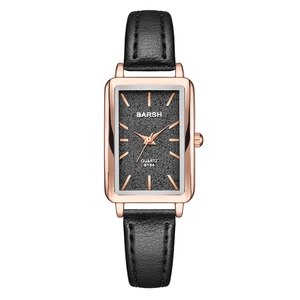 Macro shot of rectangular rose gold case with black leather strap and textured dial