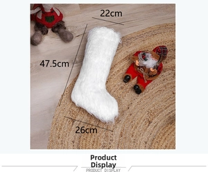 Detailed view of white faux fur Christmas stocking with size dimensions on woven rug