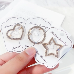 Detailed view of silver alloy brooches in heart and star shapes with sparkly rhinestones