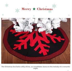 Detailed close-up of knitted Christmas tree skirt with red snowflake and black base