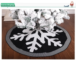 Detailed texture of black and white knitted Christmas tree skirt with snowflake pattern