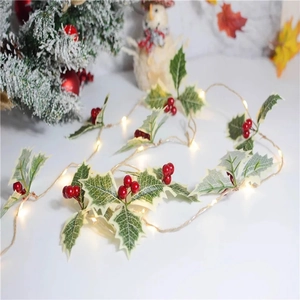 Close-up of LED Christmas string lights with red berries and snowy holly leaves decor