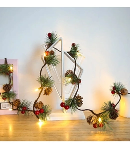 Detail of Christmas pine needle garland with warm LED lights, berries, and pinecones