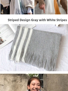 Détail d'une écharpe en maille rayée douce gris et blanc avec de longues franges au bout