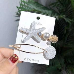 Detail of starfish hair clip set with faux pearls, blue crystals and shell charms