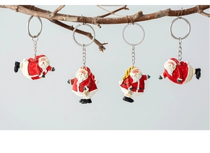 Set of four resin Santa Claus keychains hanging on a branch for Christmas decor