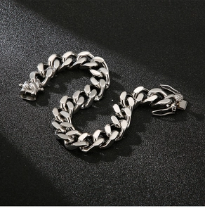 Detailed view of silver Cuban link chain bracelet with polished finish on black texture